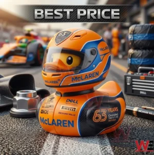 An orange McLaren themed rubber duck wearing a miniature racing helmet sits on a racetrack. The duck features 63rd anniversary branding and various sponsor logos with a racing car in the background.