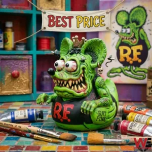 A green Rat Fink collector figure with bloodshot eyes on an artist workbench with paint tubes and brushes!