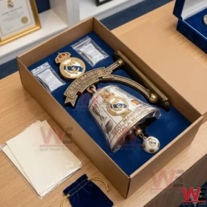 An unboxed Real Madrid 124th anniversary bell set laying in a blue velvet lined packaging box on a wooden table!