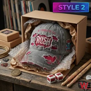 A grey Rush cap inside a shipping box surrounded by drumsticks guitar picks and logo dice on a wooden desk!