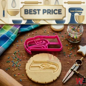 A pink seahawk head cookie cutter and a piece of embossed dough on a wooden surface with baking accessories!