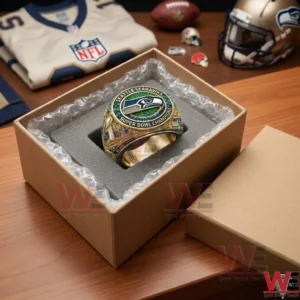 A jeweled Seahawks Super Bowl ring in a shipping box on a desk with a football jersey and helmet!