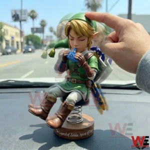 Hand touching a Link figure on a car dashboard!