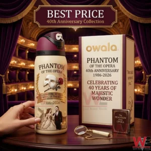 A detailed photograph showcasing a special edition Phantom of the Opera 40th anniversary Owala water bottle and gift box on a dark wooden table in a classic theater setting.