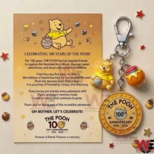 The Winnie the Pooh 100th Anniversary Keychain 3 Pooh Bear 100th Anniversary keychain and commemorative card on a neutral background.