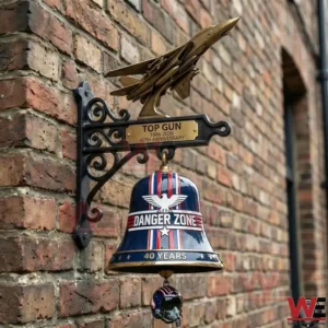 Top Gun themed wall bell with jet topper on a brick wall!
