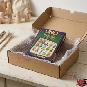 A Zelda UNO game box packed inside a cardboard shipping box with bubble wrap on a wooden surface!