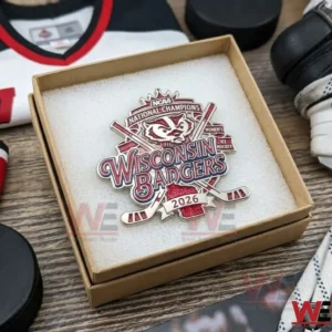 An open gift box containing a Wisconsin Badgers 2026 championship pin on a white foam cushion!