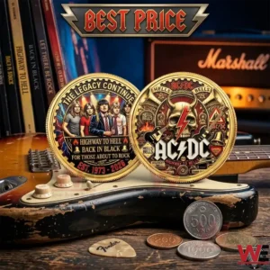 Close up shot of a double sided gold AC DC commemorative coin resting on a wooden table with guitar accessories and vinyl records in the background!