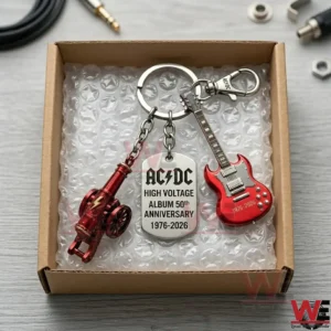 ACDC High Voltage 50th Anniversary Collector Keychain 3 A top down view of an AC DC 50th Anniversary keychain featuring a guitar cannon and engraved tag in a packaging box!