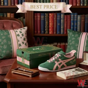 Close up of green suede sneakers with pink stripes and details resting on a dark wood table in a classic library setting next to a branded AKA shoebox!
