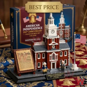 A miniature building kit for a famous historical structure is shown in a library setting. The building is complete with small plastic bricks and stands on a platform next to two tiny historical people figures and a flag. A framed copy of a founding document is also present.
