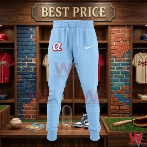 Light blue athletic sweatpants with a team logo displayed on a wooden counter in a sports locker room.