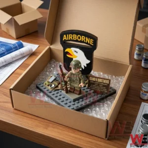An open cardboard box containing a soldier toy set on bubble wrap placed on a workbench with architectural plans!