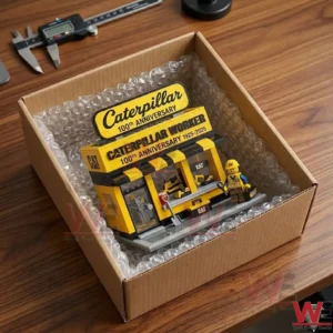 A top down view of a toy building set inside a shipping box lined with bubble wrap! The box is on a wooden desk next to a digital measuring tool!
