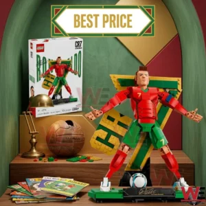 A Lego figure of Cristiano Ronaldo in a red and green soccer uniform stands on a green base next to its packaging on a wooden desk.