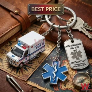 A detailed view of a multi charm EMS anniversary keychain on a vintage map! The charms include a small ambulance a blue Star of Life and an engraved metal tag! A leather notebook keys and a compass surround the item!