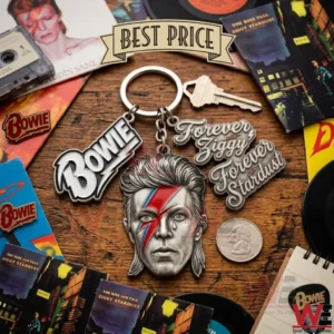 A metal keychain with a portrait of David Bowie and several logo charms is displayed among classic rock music items and records on a wooden desk!