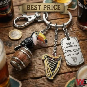 Guinness branded metal keychain featuring a toucan on a barrel and a commemorative silver plaque on a rustic table!