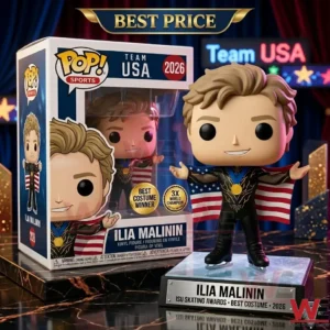 A vinyl figure of Ilia Malinin in a skating outfit with a gold medal and holding a US flag next to its product box! They rest on a marble counter in front of blue curtains and signs for Team USA!
