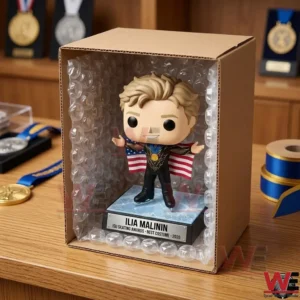 Ilia Malinin 2026 World Champion Victory Edition POP! Figure 5 A close up photo of a vinyl figure of Ilia Malinin inside an open cardboard box surrounded by bubble wrap! The box is on a wooden desk with medals in the background! A roll of blue ribbon is to the right!