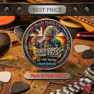 Close up of a rock band commemorative coin with detailed mascot art surrounded by personal items on a wood table!