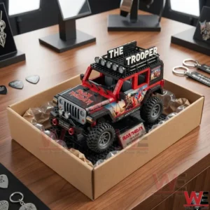An Iron Maiden themed brick Jeep model packed in a cardboard box with bubble wrap on a wooden desk with band merchandise.