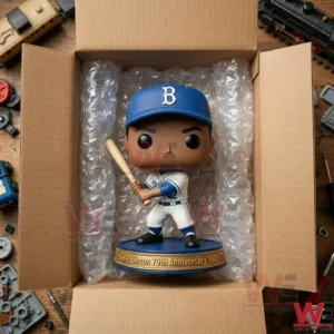 A vinyl Jackie Robinson figure on an old baseball game board surrounded by antique gloves a gold trophy and leather cleats!