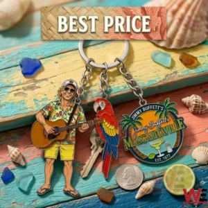 A three charm tropical keychain is shown on a beach themed background! It features a guitar player a parrot and a Margaritaville logo surrounded by seashells and sea glass!