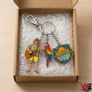 A colorful three charm keychain is packed inside a cardboard box with bubble wrap! The charms include a musician a parrot and a tropical logo!