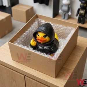 JUST FUCK IT Attitude Duck 5 Top view of a yellow duck figure in a black hoodie inside a shipping box filled with bubble wrap!