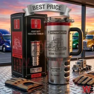 A stainless steel tumbler with a Kenworth truck engraving and its black box sitting on a metal floor! Driving gloves and a miniature truck are nearby while large semi trucks park outside in the sunset!