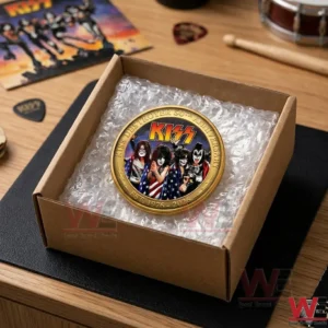 A KISS 50th Anniversary gold coin packaged in a brown mailing box with musical accessories in the background!