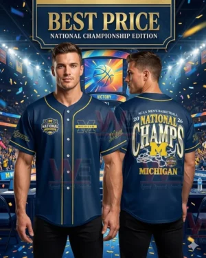 A man showcasing the front and back of a navy Michigan 2026 National Championship basketball jersey in a cheering stadium.