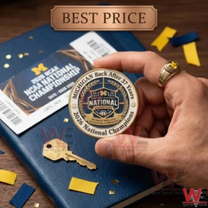 Michigan Wolverines 2026 National Champions Coin 4 Close up of a hand holding a gold championship coin with a game ticket and key!