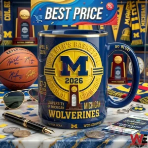 A celebratory Michigan Wolverines mug on a table with sports memorabilia!