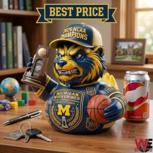 Collectible Michigan Wolverine mascot figure celebrating a 2026 NCAA championship on a desk with a trophy and basketball.