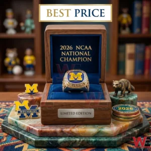 A championship ring in a wooden box with gold text alongside pins a wolverine statue and coins!