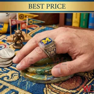 A hand wearing a detailed championship ring resting on a stone coaster surrounded by coins a statue and pennants!