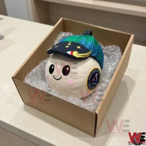 NASA Artemis II Rise Zero G Mascot Plush 5 Packaging shot of a moon plush toy inside a brown shipping box with plastic wrap!