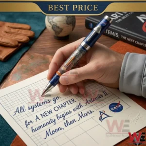 A hand writes on grid paper with a detailed blue NASA pen that has a rocket sculpture on its side and a capsule shaped clip.