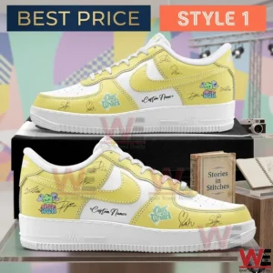 Side profile of yellow and white low top sneakers with artistic doodles and signatures resting on a black box!