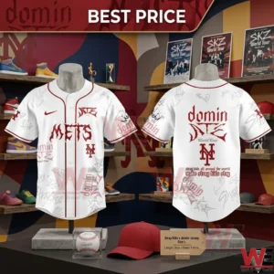 White baseball jerseys with red Mets and Stray Kids branding hanging in a retail display area with sneakers and posters!
