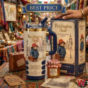 A Paddington Bear themed insulated tumbler stands on a table with its box! A jar of marmalade and a small brown suitcase are also visible!