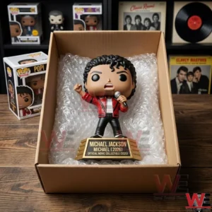 An open shipping box containing a Michael Jackson vinyl figure on a gold base protected by bubble wrap on a wooden ledge near collector shelves!
