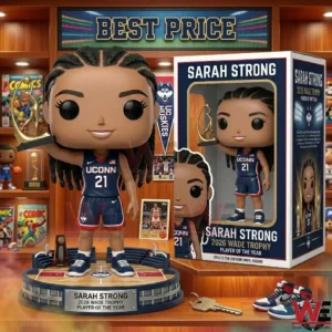 A vinyl figure of a female basketball player in a blue uniform holding a gold trophy next to its packaging on a wooden desk.