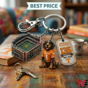 A silver anniversary keychain for the Tennessee Volunteers is displayed on a table! The charms include a football stadium a mascot dog in a jersey and a commemorative anniversary tag!