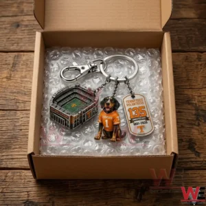 A Tennessee Volunteers themed keychain is packed in a cardboard box with bubble wrap! It features a stadium charm a mascot dog charm and an anniversary tag charm!