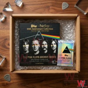 An open shipping box containing a black Pink Floyd collector box and a silver card pack protected by bubble wrap on a wooden desk with prisms!