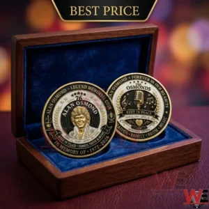 An open wooden gift box holding two circular gold coins dedicated to Alan Osmond against a blurred lights background!